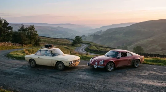 Deux véhicules de collection côte à côte sur une route de campagne sinueuse au lever du soleil, illustrant la différence entre rallye touristique et compétition chronométrée